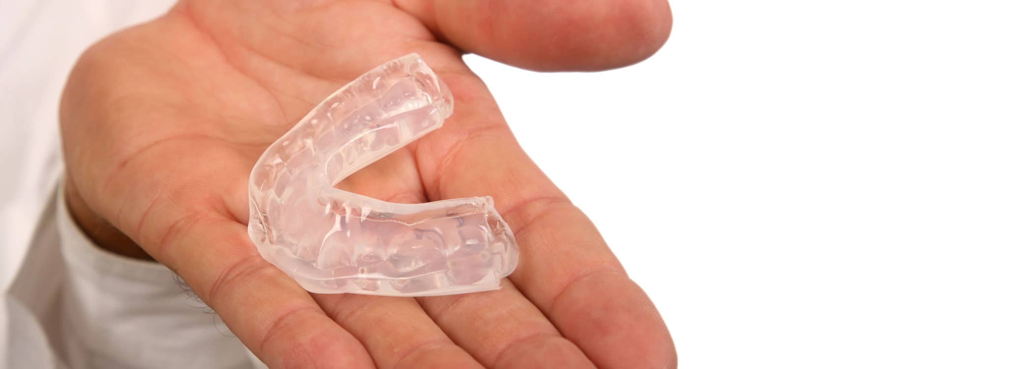 Mouth guard in someone's palm.